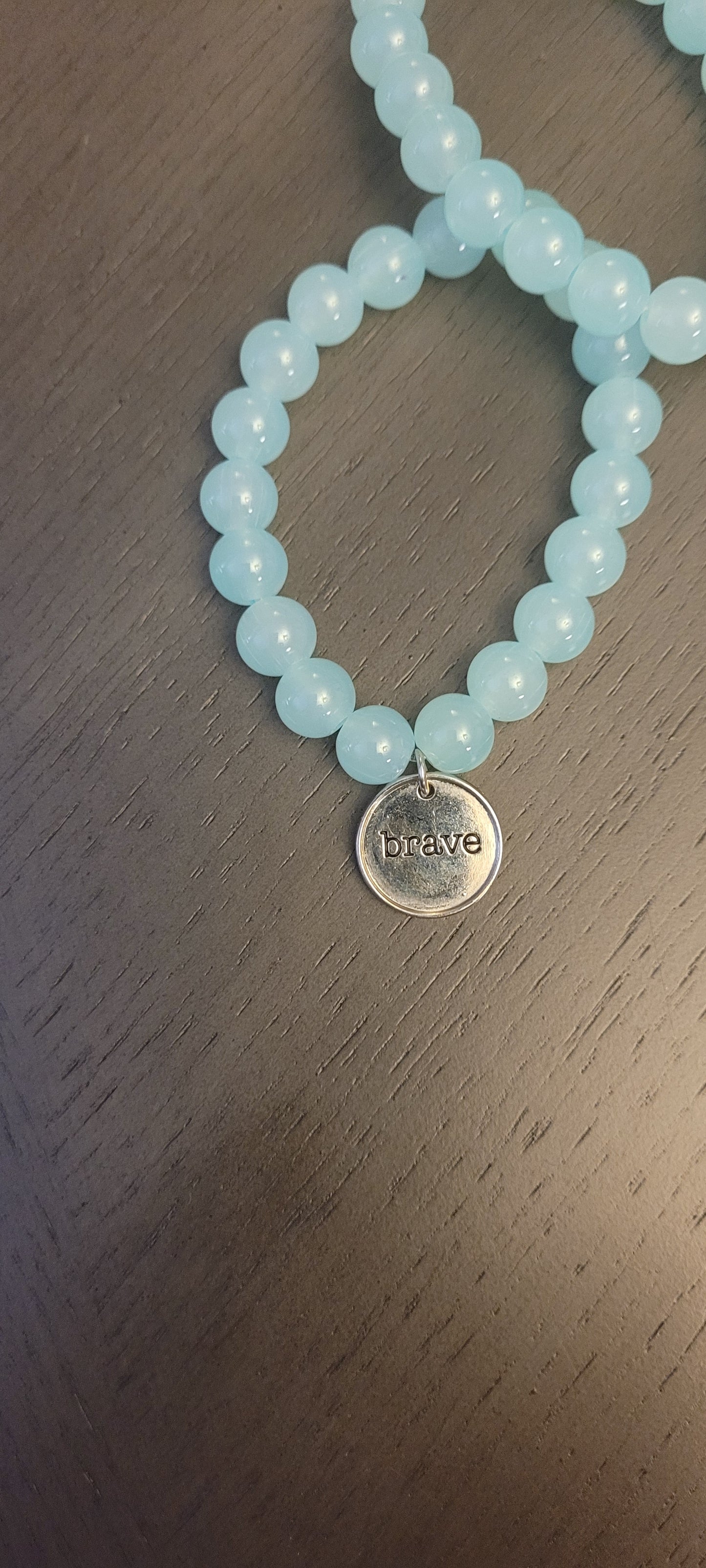 Light blue stretch bracelet with brave charm